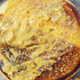 underside of the top bun of chicken sandwich, with sauce visible